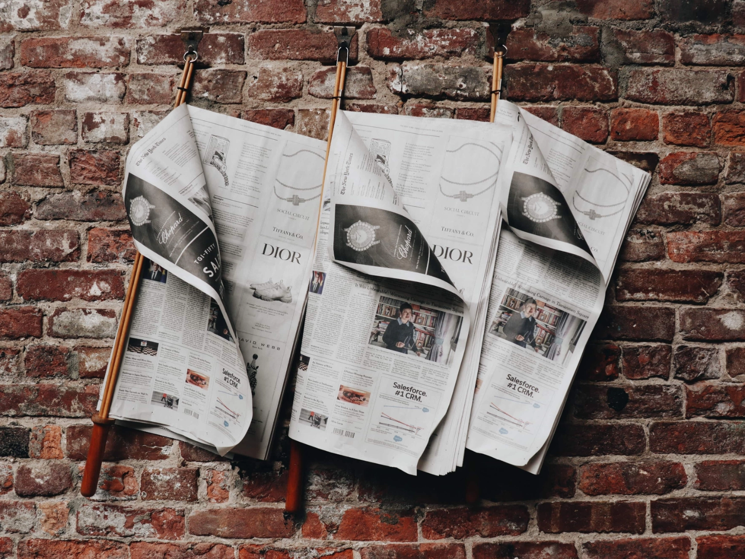Symbolbild Presse: Zeitungen hängen an Holzhalterungen an einer Wand