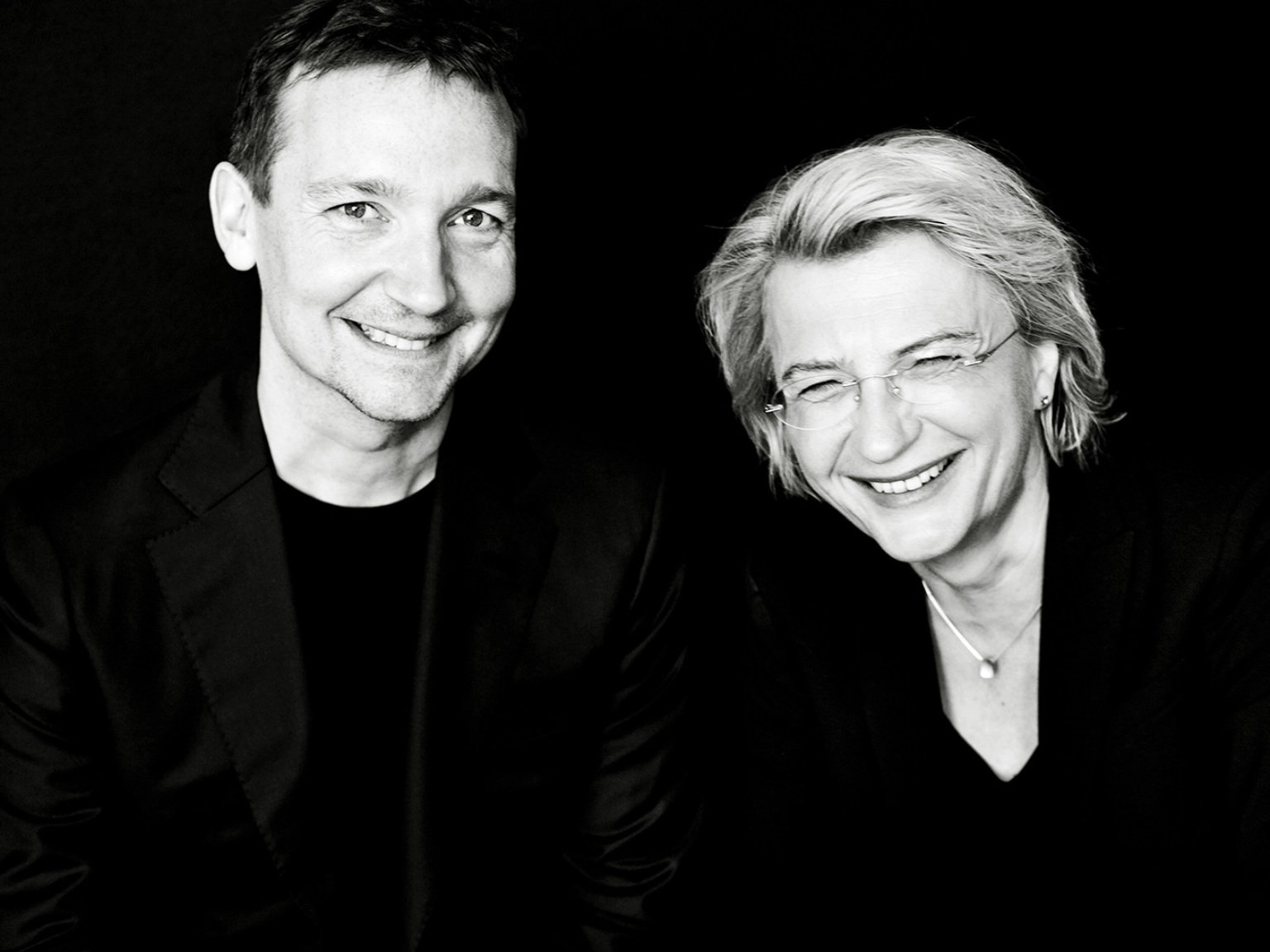 Die Künstlerische Leitung des Violinwettbewerbs: Antje Weithaas (rechts) und Oliver Wille (links). Beide lachen in die Kamera.